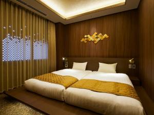 a bedroom with a large bed in a room at Minn Kanazawa in Kanazawa