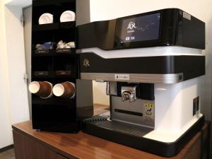 Una cafetera espresso sentada en la parte superior de un mostrador en Moriyama Art Hotel, en Moriyama