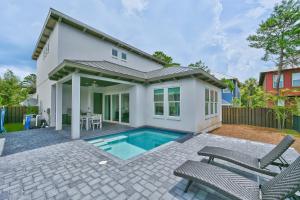 una casa con piscina e due sedie di Carefree Days a Santa Rosa Beach