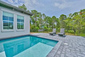 una piscina con due sedie accanto a una casa di Carefree Days a Santa Rosa Beach
