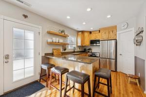 a kitchen with wooden cabinets and a bar with stools at Creekside cutie 3br 2.5ba near skiing sleeps 8 in Kamas