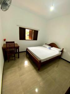 Un dormitorio con una cama, una silla y una ventana en Home in Mirissa, en Mirissa