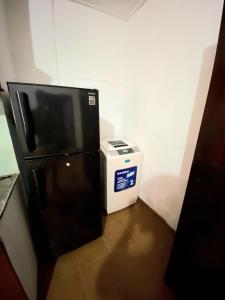 Un refrigerador negro en una habitación al lado de un microondas. en Home in Mirissa, en Mirissa
