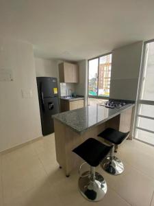 a kitchen with a counter and two bar stools at Apartamento en Manizales in Manizales
