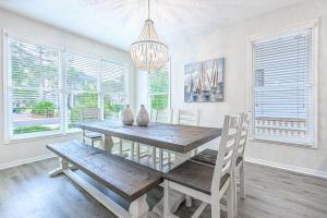 una sala da pranzo con tavolo in legno e lampadario pendente di Cassine Dream a Santa Rosa Beach