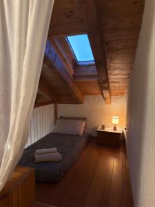 a attic bedroom with a bed and a window at Il Rifugio sul Lago di Como sopra Bellano in Bellano