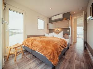 a bedroom with a large bed and a large window at Hausboot am Gräbendorfer in Gräbendorf
