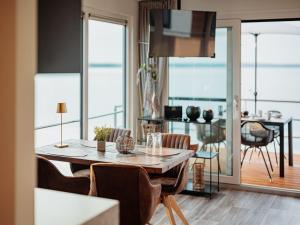 a dining room with a table and chairs with a view of the ocean at Hausboot am Gräbendorfer in Gräbendorf