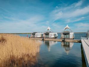 a couple of buildings on a dock in the water at Hausboot für 4 Personen auf dem Gräbendorfer See in Gräbendorf +32 photos