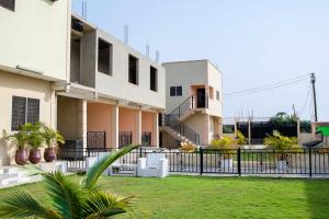 a building with a fence and a grass yard at Kwanskrom Villa Biggies Homes in Winneba