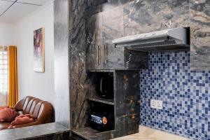 a living room with two chairs and a stove at Kwanskrom Villa Biggies Homes in Winneba