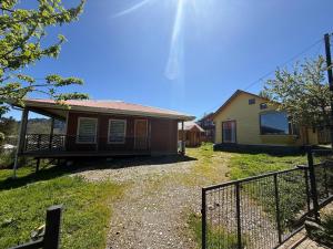 a house with a fence in front of it at Cabañas dunn in Puerto Cisnes +8 photos