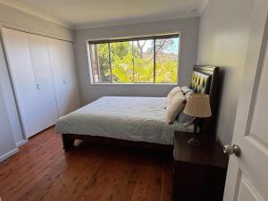 a bedroom with a bed and a window at Bright & Spacious Getaway - East Gosford in Point Frederick +9 photos
