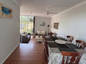 a dining room and living room with a table and chairs at Bright & Spacious Getaway - East Gosford in Point Frederick