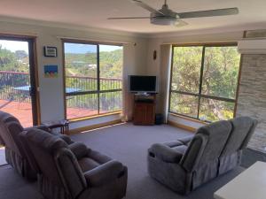 d'un salon avec canapés et télévision ainsi que d'un balcon. dans l'établissement Jupiter 69, à Evergreen