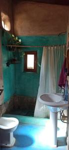 ein grünes Bad mit einem Waschbecken und einem WC in der Unterkunft Mambo Paraíso in Los Sauces