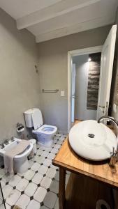 a bathroom with a toilet and a sink at Cabañas Hacia El Sur in El Hoyo +32 photos