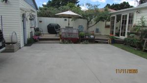 a patio with an umbrella next to a house at Cozy Haven - Waihi in Waihi