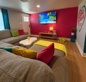 ein Wohnzimmer mit Sofa und Fernseher in der Unterkunft Casa Amor Texas A Vibrant Villa near BS&W with King Bed in Temple