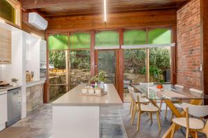 a kitchen with a brick wall and a table with chairs at Bendigo Signature Accommodation on Vine in Bendigo +24 photos