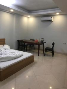 Schlafzimmer mit einem Bett, einem Tisch und einem Stuhl in der Unterkunft Classic Hotel in Hanoi