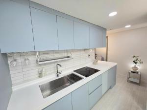 eine Küche mit weißen Schränken und einer Spüle in der Unterkunft 2 Bathrooms & 3 Rooms, New Elevator in Seoul + 14 Fotos