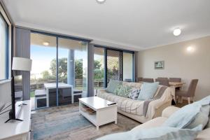 Nautilus 2 - Ground Floor Unit في هاوكس نيست: غرفة معيشة بها أريكة وطاولة