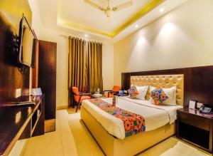 una habitación de hotel con una cama y un televisor en Hotel Sunshine At Delhi Airport, en Dwarka, Nueva Delhi
