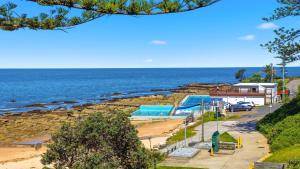 a view of a beach with the ocean at Beachfront Breeze - Family Getaway By Holidayco in The Entrance