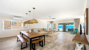 a living room with a table and a couch at Beachfront Breeze - Family Getaway By Holidayco in The Entrance