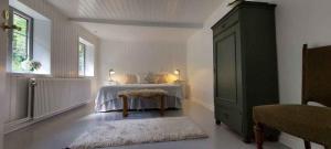 a bedroom with a bed with a table and a window at Hyggelig Hus Nær Arrild Ferieby in Arrild