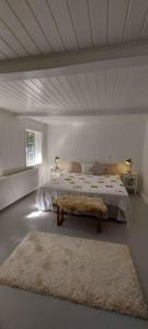 a bedroom with a large bed and a rug at Hyggelig Hus Nær Arrild Ferieby in Arrild