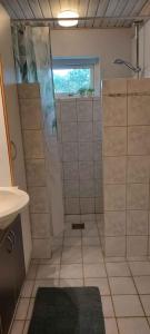 a bathroom with a shower with a window and a sink at Hyggelig Hus Nær Arrild Ferieby in Arrild