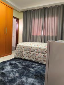 a bedroom with a bed in front of a window at Lar Doce Lar Realizando Sono!!! in Arcos