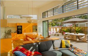 un salon et une cuisine avec un canapé et une table dans l'établissement Hosts on the Coast All Decked Out, à Whitianga