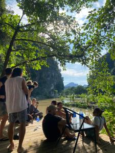 Vũ LâmBig D hostel的一群人坐在河边的甲板上