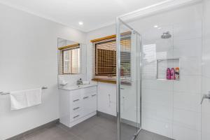 a white bathroom with a shower and a sink at Cathedral View - Sleeps 16 in Bendigo +44 photos