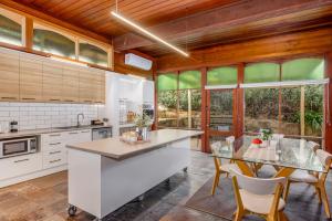 a kitchen with white cabinets and a table with chairs at Cathedral View - Sleeps 16 in Bendigo