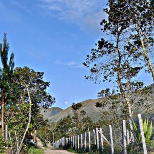 a white fence with mountains in the background at Cabaña Villa Serena in Villa de Leyva +6 photos