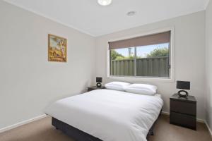 a white bedroom with a bed and a window at Time to Relax in Portarlington