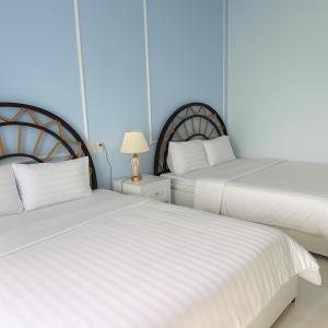 two beds sitting next to each other in a bedroom at King Hotel Hải Phòng in Hai Phong