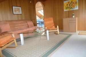 een woonkamer met een glazen tafel en een bank bij Ferienwohnung Casa Marlies In Daun in Daun