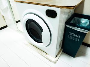 eine Waschmaschine neben einem Mülleimer in der Unterkunft -智 tomo- 難波 天王寺まで約15分 大阪観光に便利な和風宿 無料Wi-Fi in Osaka