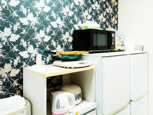 eine Mikrowelle, die auf einem Schrank in einer Küche steht in der Unterkunft -智 tomo- 難波 天王寺まで約15分 大阪観光に便利な和風宿 無料Wi-Fi in Osaka