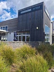 Un edificio con un cartel al costado. en Pohutukawa Studio on Hugoway, Papamoa Beach, en Papamoa