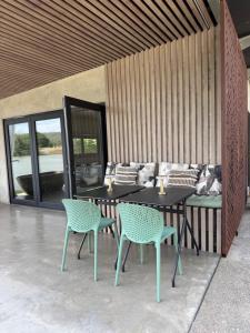 a patio with a table and chairs and a couch at Chapel Cove Retreat - Private Tiny House with Boat Ramp in Sackville Reach +4 photos