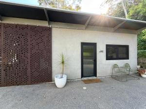 a house with a plant in a pot next to a door at Chapel Cove Retreat - Private Tiny House with Boat Ramp in Sackville Reach
