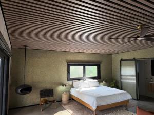 a bedroom with a large bed with a wooden ceiling at Chapel Cove Retreat - Private Tiny House with Boat Ramp in Sackville Reach