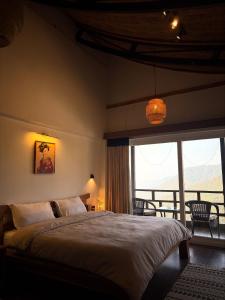 um quarto com uma cama grande e uma janela grande em The Wild Sakura em Mukteswar mais 72 fotografias