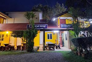 a building with a picnic table in front of it at night at D Teratak Motel in Kuah